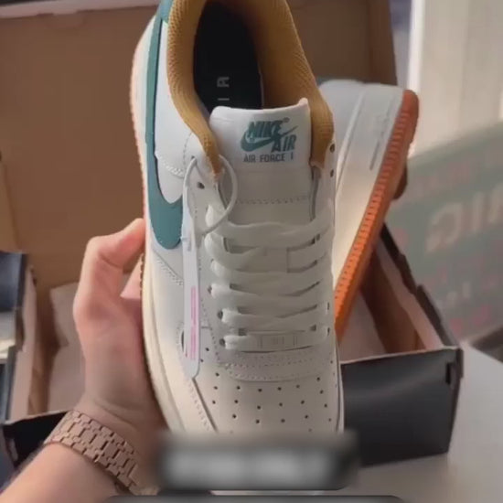 White and orange Nike-style sneakers with blue swoosh design, showcased in hand for online product listing.