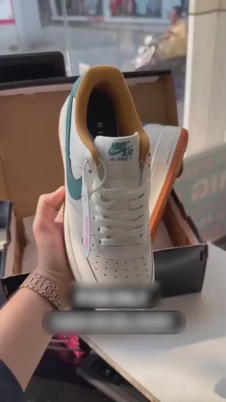 White and orange Nike-style sneakers with blue swoosh design, showcased in hand for online product listing.